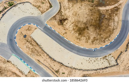 dua mobil di tikungan s di lintasan balap di Motercity Beer Sheva