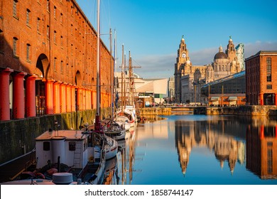 De Drie Gratiën, gezien vanaf Royal Albert Dock met historische gebouwen en weerspiegeling in Engeland, Verenigd Koninkrijk.