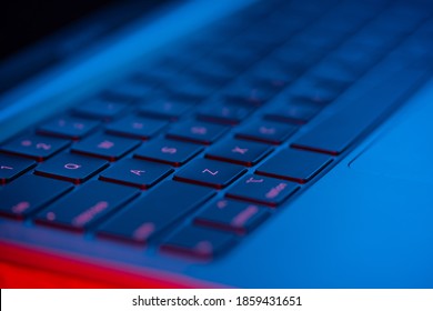 ネオンライト付きのノートパソコンのキーボードのマクロショット。クローズ アップ ビュー。現代の技術の概念。