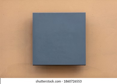 Leeres Wandschild aus Metall, graue Beschilderung in quadratischer Form auf orangefarbenem Wandhintergrund, leere Vorlage, Kopierraum.