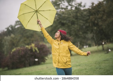 Good mood. Cute mulatta with yellow umbrella feeling happy