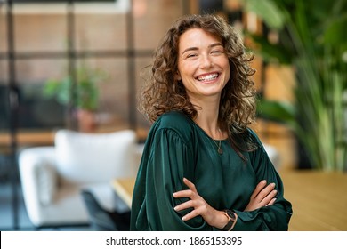 組んだ腕でカメラを見て笑顔の若い女性の肖像画。クリエイティブ オフィスに立っている幸せな女の子。コピー スペースでオフィスに立っている成功した実業家。