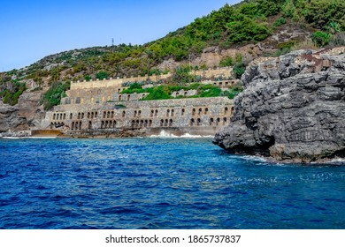 Muro de piedra antigua con muchos agujeros arqueados en el parque abandonado Emirgan Ulas Mesire Yeri en Alanya (Turquía). Paisaje con una roca de granito, edificio antiguo y un bosque en la montaña en la costa mediterránea