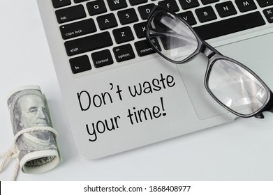 メガネ、お金の紙幣、ラップトップの上面図に、「時間を無駄にしないでください!」というテキストが書かれています。ビジネスと教育のコンセプト。