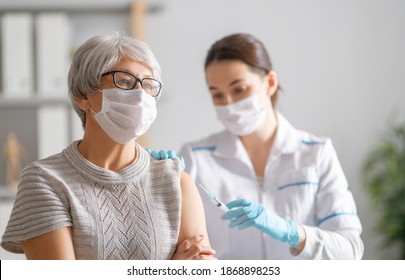 Doctor care vaccinează o femeie în vârstă. Protecție contra virus. COVID-2019.