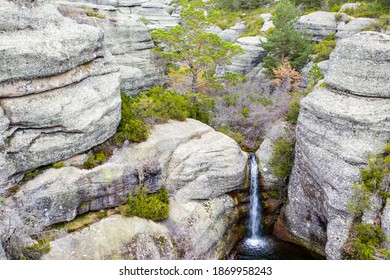 Landschaft mit Felsen und kleinen Wasserfällen in der schwarzen Lagune der Stadt Neila, Las Calderas, von einer Drohne aus gesehen.