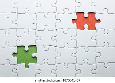 In einem Puzzle fehlen zwei Teile, die in verschiedenen Farben fertiggestellt werden müssen. weiße Stücke und ein Stück in Grün und eines in Orange, um Text hinzuzufügen