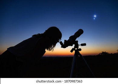 Người phụ nữ nhìn bầu trời đêm bằng kính thiên văn nghiệp dư.