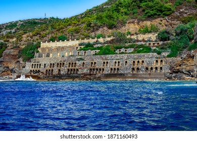 Antiguo muro de piedra con agujeros arqueados en una playa inundada en el parque Emirgan Ulas Mesire Yeri en Alanya (Turquía). Paisaje marino tropical exótico con edificio vintage en roca