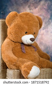 Riesiger Teddybär, der auf Holzstuhl sitzt