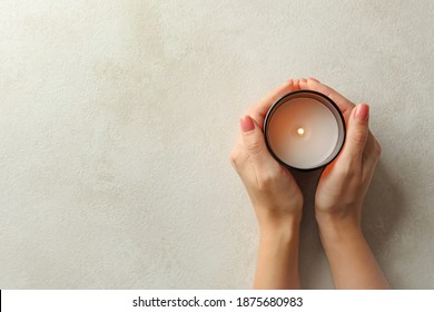 Female hands holding scented candle, top view