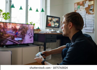 Riga, Latvia - November 24 2020: Man playing video game PlayStation 5 Sony reveals PS5 console and games. Dual sense controller. Spider-Man: Miles Morales is biggest launch. Gamer man holding joystick