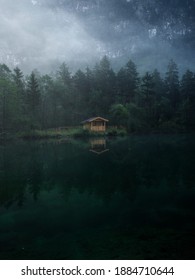 Low clouds fog misty mood reflection forest wood cabin in clear calm alpine mountain Lake Bluntausee Salzburg Austria