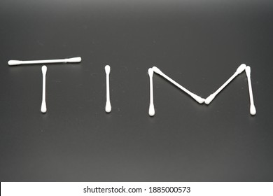 暗い背景に分離された 7 つの綿棒は、TIM の名前を書きます