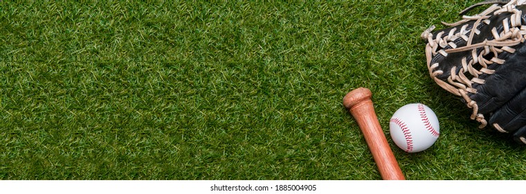 緑の芝生のフィールドに野球のバット、グローブ、ボール。テキストと広告のコピー スペースを持つスポーツ テーマの背景