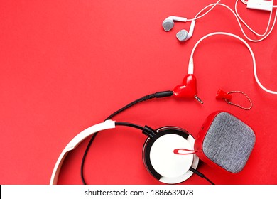 Un divisor de auriculares en forma de corazón para una pareja enamorada. Conectado a un altavoz portátil rojo y dos pares de auriculares: plano. día de san valentín, amor, tecnología moderna, espacio de copia