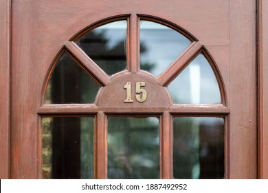 Lima belas digit logam di pintu depan kayu cokelat