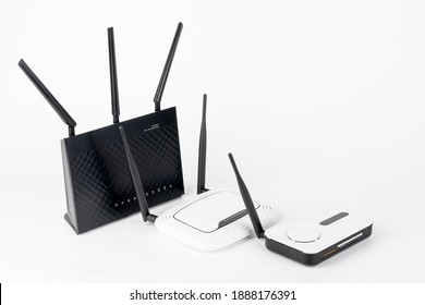Three  Wi-Fi  routers, wireless devices with one, two and three antennas.  Black router has five Gigabit Ethernet ports, ultrafast USB 3.1 port and  USB 2.0 port. 