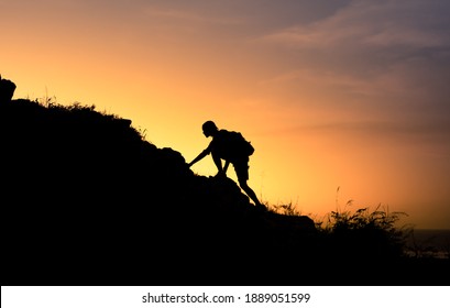 Silueta de hombre de montaña subiendo por un borde empinado de la montaña. Personas que alcanzan objetivos de vida y nunca abandonan el concepto.