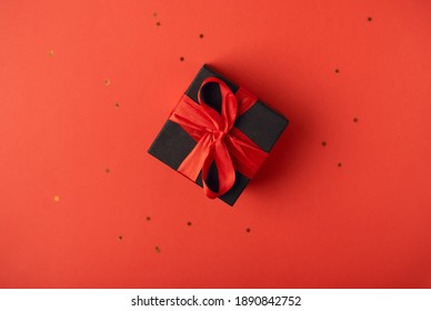 Cajas de regalo negras con cinta roja sobre fondo rojo. El Concepto Del Día De San Valentín.