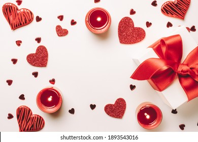 Valentinstag Hintergrund: rote Liebesherzen, romantische Geschenkbox, Kerze auf weißem Tisch. Februar Romantik Geschenkkarte. Ansicht von oben. Sicht von oben