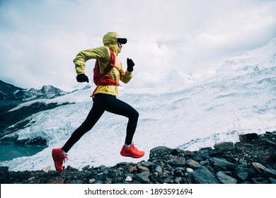 冬の雪山の頂上に駆け上がる女性トレイル ランナー クロスカントリー