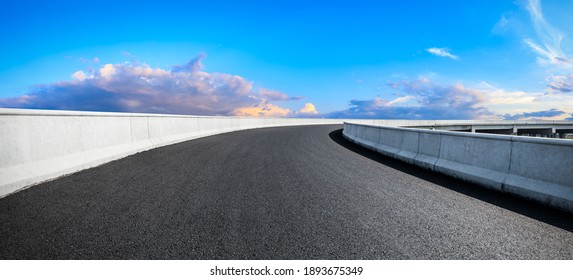 Rrugë e zbrazët e asfaltit dhe qielli blu me retë e bardha. Sfondi i rrugës.