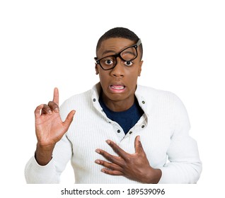 El retrato del primer, el hombre joven aturdido, empollón con los vidrios grandes ensució la cara, abre la boca, levantando el dedo diciendo perdón, fondo blanco aislado. Sentimientos de expresión facial de emoción humana negativa.
