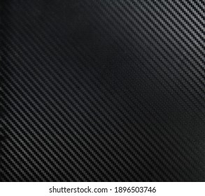 Un material din fibră de carbon închisă la culoare. O textură industrială întunecată potrivită ca fundal pentru compoziții