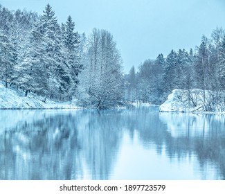 凍った湖の鏡面に映る雪に覆われた木々の冬の風景。1月の風景。寒い霜の日。森と雪に覆われた海岸線の美しいシーン。凍った川の氷。