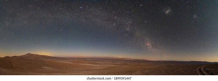 アタカマ砂漠の広大な砂地の上の天の川の素晴らしいパノラマ ビュー。銀河の腕が星の間にアーチを作っている畏敬の念を起こさせる夜空の景色。牧歌的でやる気を起こさせる風景。