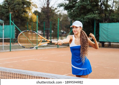 Sicherer Umgang mit dem Ball beim Spielen im Netz. Eine attraktive, schöne Tennisspielerin, die Übungen macht, um ihr Können zu verbessern. Spiele in Bewegung, Action. Lieblingssport - Tennis.