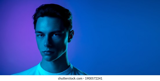 Nacht. Das Porträt eines hübschen kaukasischen Mannes isoliert auf violettem Studiohintergrund in Neon, Monochrom. Schönes männliches Modell. Konzept menschlicher Emotionen, Gesichtsausdruck, Verkauf, Werbung, Mode und Schönheit