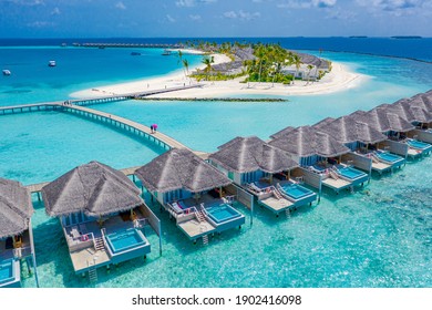 Luftbild der Malediven-Insel, Luxus-Wasservillen-Resort und Holzsteg. Schöner Himmel- und Ozeanlagunen-Strandhintergrund. Sommerferien Urlaub und Reisekonzept. Paradiesisches Luftlandschaftspanorama