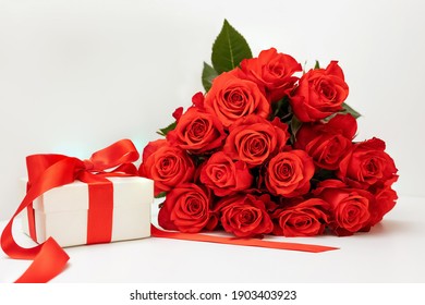 bouquet de roses écarlates lumineuses, coffret cadeau avec un ruban lumineux sur fond blanc avec un emplacement pour le texte, concept de carte de voeux joyeuse Saint-Valentin, 8 mars, joyeux anniversaire