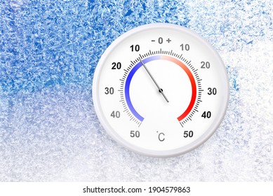 凍った窓の摂氏スケールの温度計はマイナス 11 度を示しています