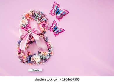 Internationaler Frauentag. Banner, Flyer, schöne Postkarte für den 8. März. Blumen und Schmetterlinge in Form der Zahl 8 auf rosa Hintergrund.