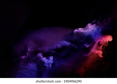 Art photo of smoke moves on black background. Beautiful swirling colorful smoke.