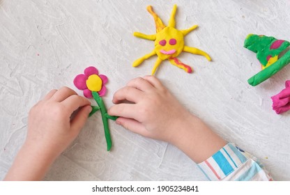 カラフルな粘土生地、粘土、粘土を使った家庭教育ゲームから花や太陽などを作る少女の手。初期開発コンセプト