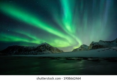 Noorderlicht aan de nachtelijke hemel. Aurora Borealis over het strand van Skagsanden op de Lofoten-eilanden. Noord Noorwegen. Winterse sterrenhemel.