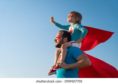 Gia đình siêu anh hùng vui chơi ngoài trời. Hai cha con chơi đùa trên nền trời mùa hè xanh. Khái niệm tưởng tượng và tự do