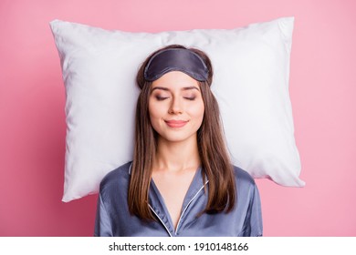Oben über dem Hochwinkel-Fotoporträt einer zufriedenen Frau, die auf einem Kissen schläft, isoliert auf pastellrosa Hintergrund