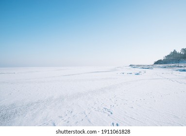cakrawala laut beku di atas es banyak salju langit biru tidak ada awan hari yang cerah di cakrawala Anda dapat melihat sedikit pantai dan jejak kaki hutan di jalan setapak salju dari orang-orang