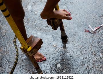 Kids playing with wooden leg in the rain at a vacation program in a neighbourhood in the city of Mariana, Minas Gerais, Brasil.