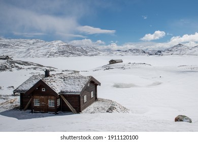 雪をかぶった家は丘の上にあり、いつも白い花の雪で覆われていて、空は青く、白い雲があります