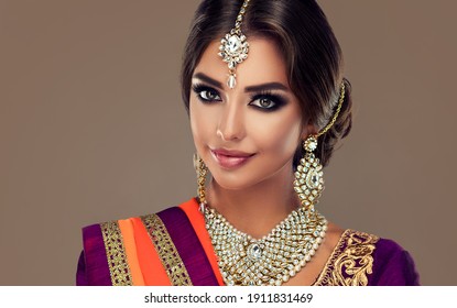 Porträt des schönen indischen Mädchens. Junges hinduistisches Frauenmodell mit Tatoo-Mehndi und Kundan-Schmuck. Traditionelles indisches Kostüm Lehenga Choli.