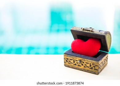 ぼやけた青い水の背景、愛とロマンスの概念、ベレンティン カード背景アイデア上のヴィンテージの木製の宝箱に赤いハート