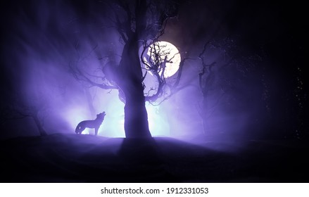 死んだ森のスカイラインと満月に対して狼の遠吠えのシルエット。創造的なアートワークの装飾。セレクティブ フォーカス