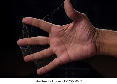 Un hombre dedos cubiertos con telaraña sobre fondo negro