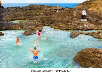 Familie strandvakantie levensstijl. Gelukkige mensen hebben plezier in het natuurlijke zeezwembad van Angel's Billabong op Pasih Uug. Beste reisbestemmingen op het eiland Bali. Populaire plek tijdens de dagtour van Nusa Penida.